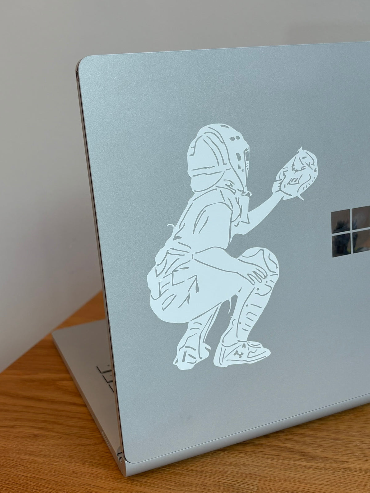 Custom baseball catcher decal personalized from photo applied to silver laptop computer.