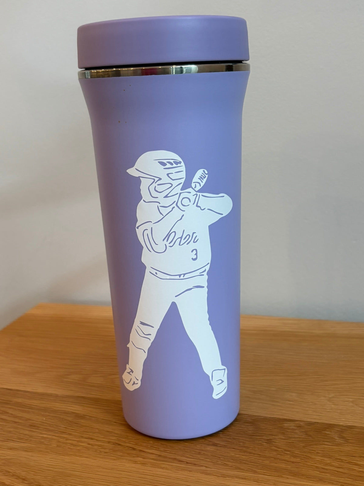 Custom baseball player vinyl decal personalized from photo applied to purple water bottle.