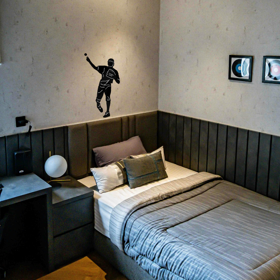 A boy's bedroom featuring a black vinyl wall decal of a baseball pitcher on the wall above a bed.