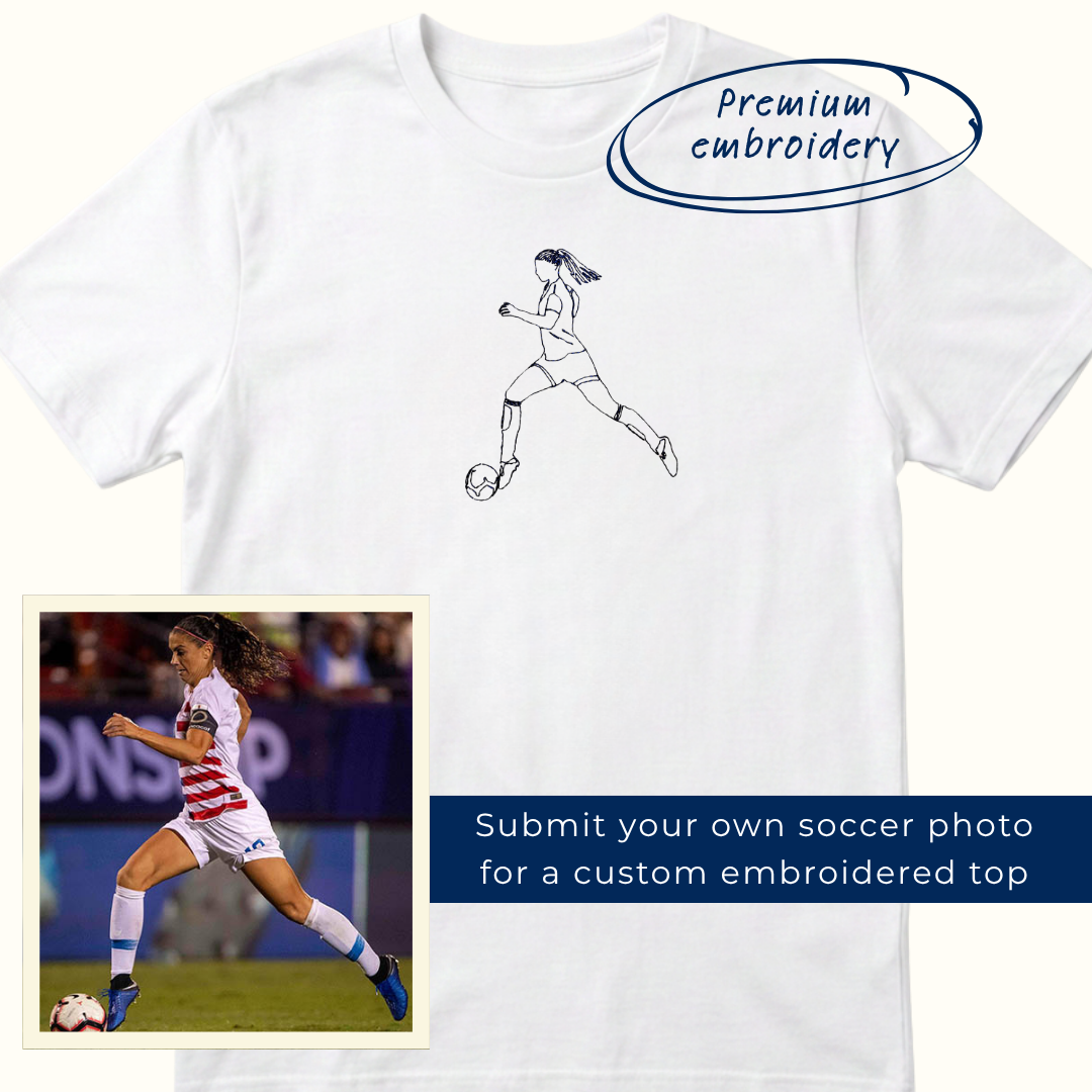 Image of girl soccer player dribbling ball embroidered onto a white tee shirt